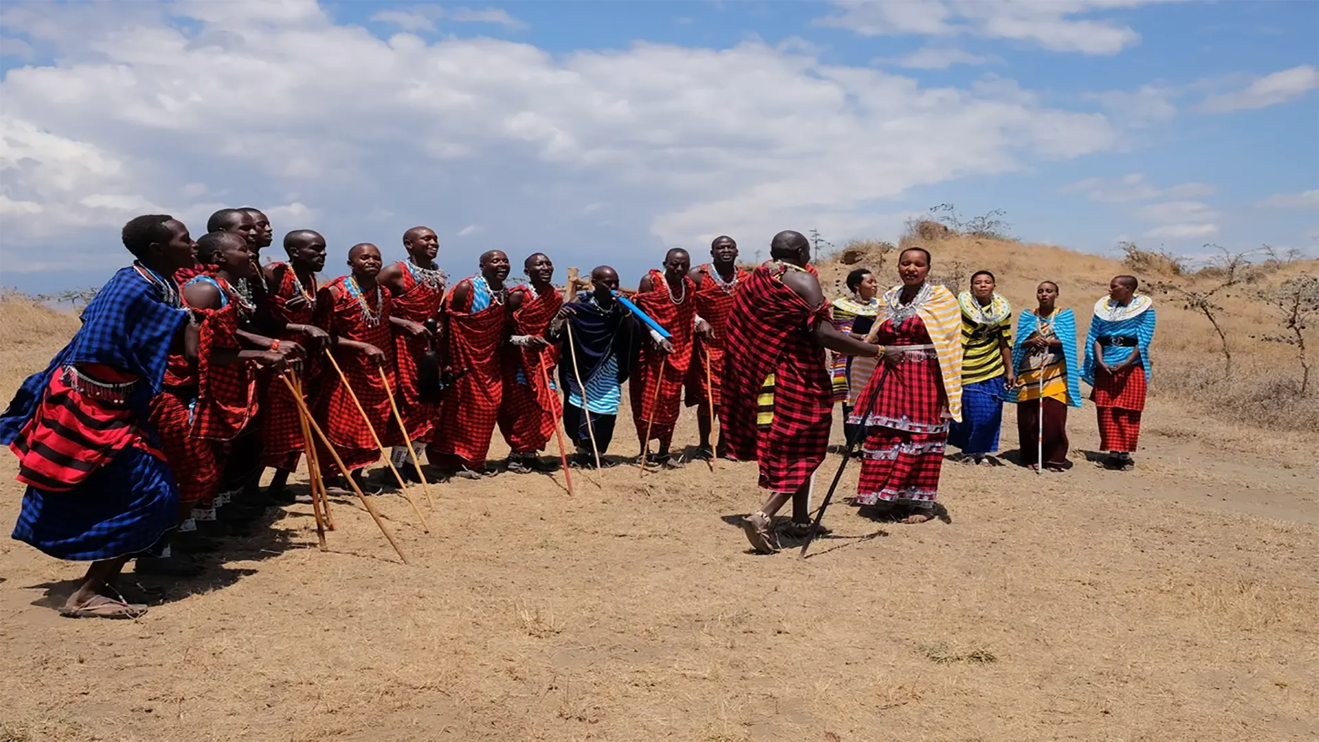 Guerrieri e donne Maasai durante la tradizionale cerimonia di benvenuto nella boma
